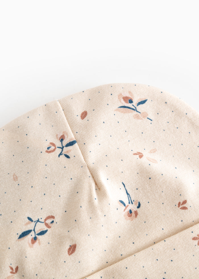 Beige babyhue med blomsterprint og synlig panel-søm