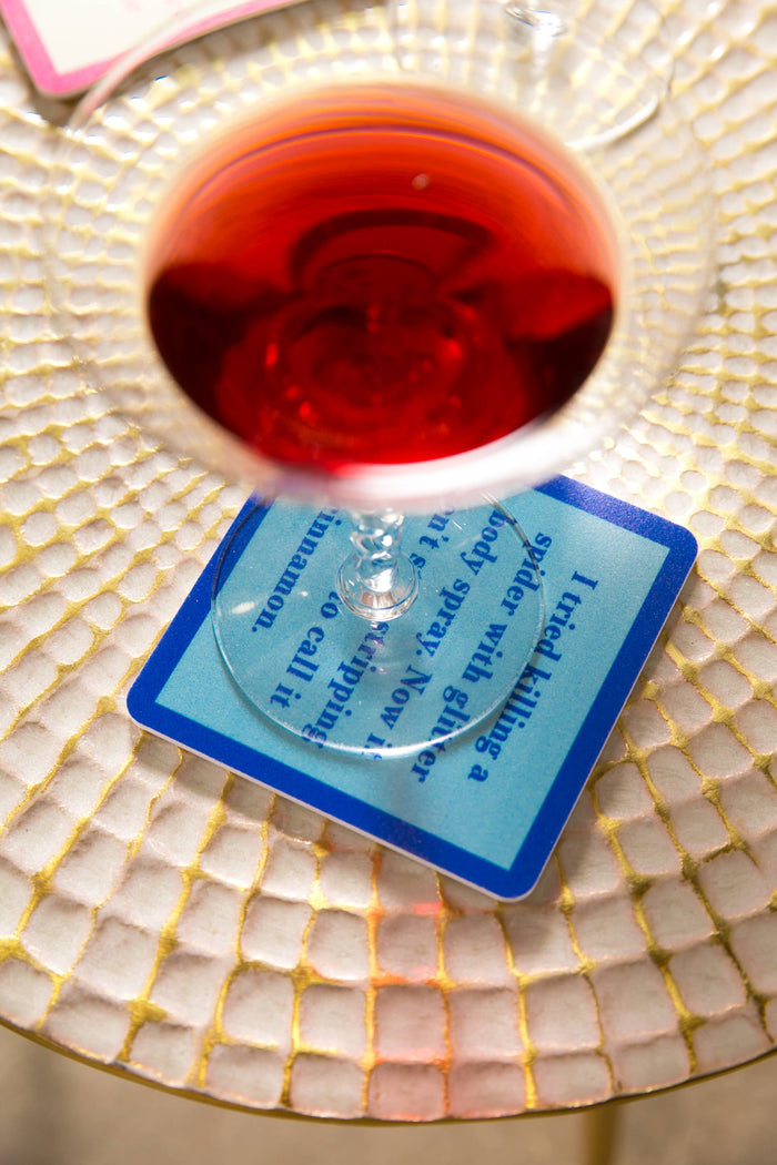 Wine glass over blue coaster with text