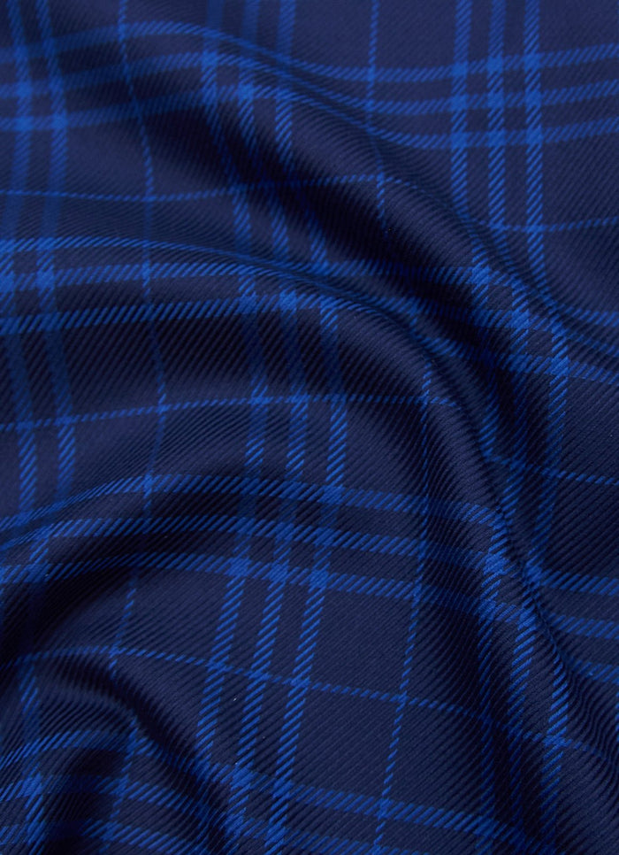 Close-up of Anoka fabric featuring blue and black tartan plaid with a diagonal pattern and visible folds.