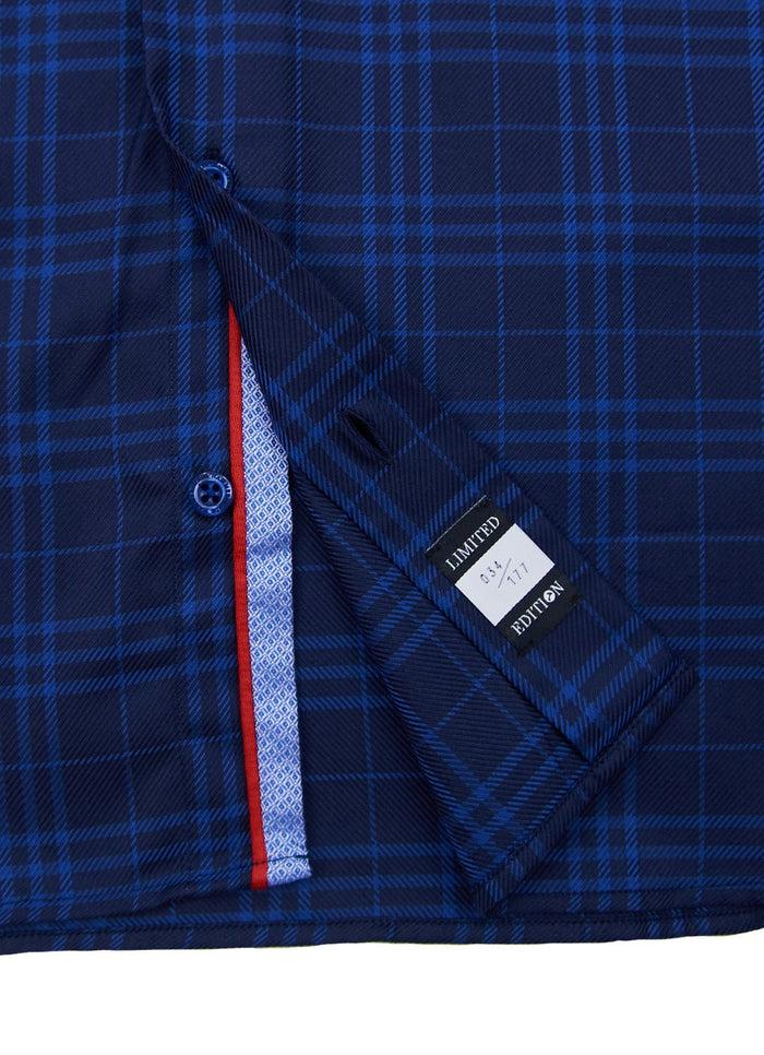 Close-up of a blue plaid Anoka shirt, partially unbuttoned to show inside stitching, red and white trim, and size and brand labels reading "LIMITED," "39/41," and "EDITION.