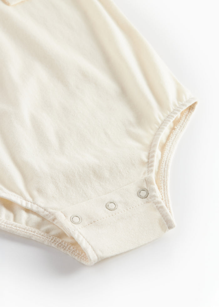 White bodystocking with collar and fine floral embroidery for baby
