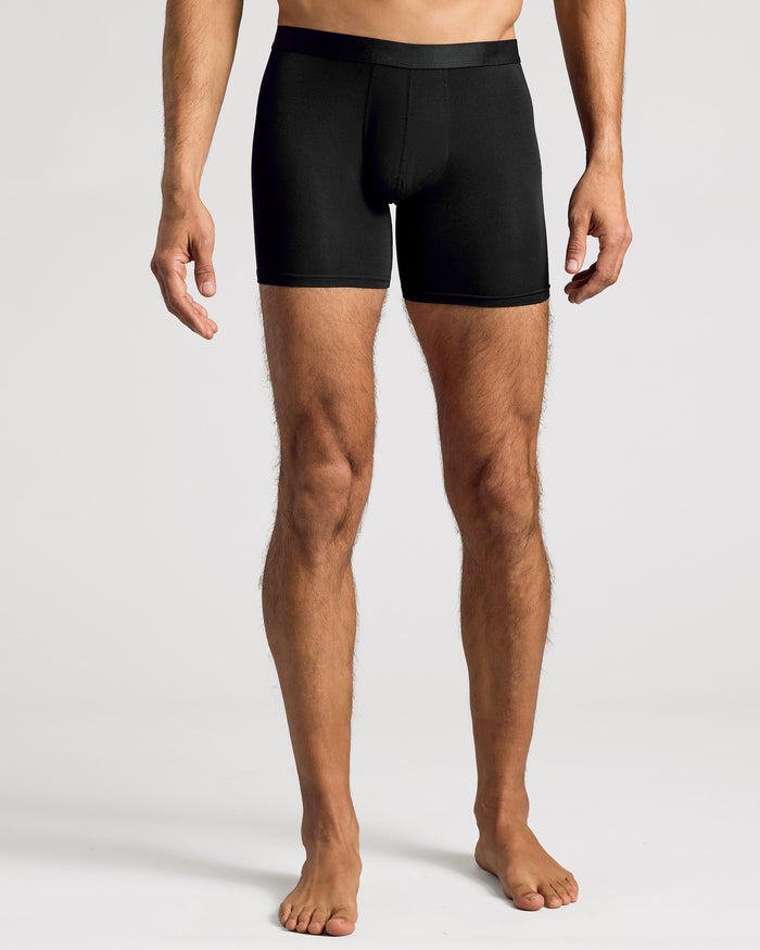 Man wearing Black Boxer Briefs 6-Pack, showcasing snug fit and mid-thigh cut.