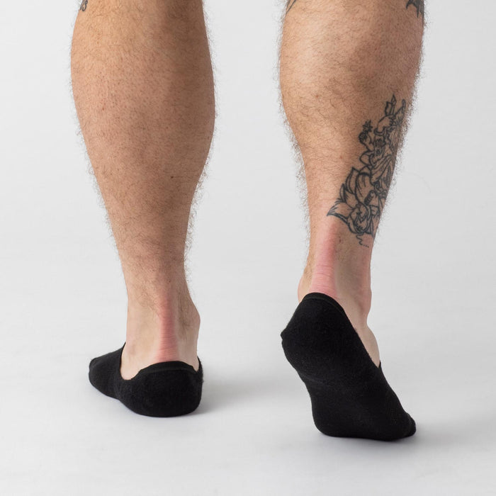 Black Never Show Socks 6-Pack on lower legs with floral tattoo.