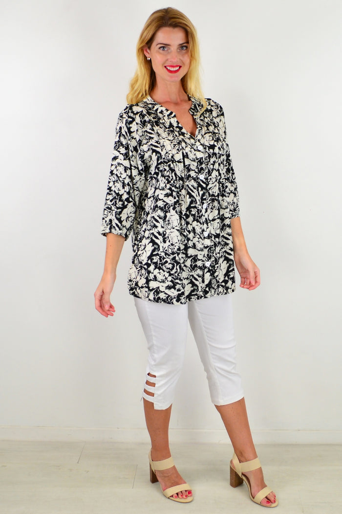 Black Roxanne floral tunic shirt by I Love Tunics with a relaxed fit and vibrant floral pattern, shown on a hanger.
