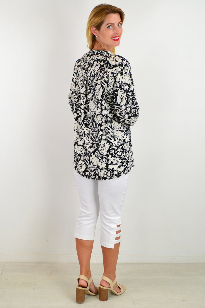 Black Roxanne floral tunic shirt by I Love Tunics, featuring a flowy fabric and vibrant floral pattern.