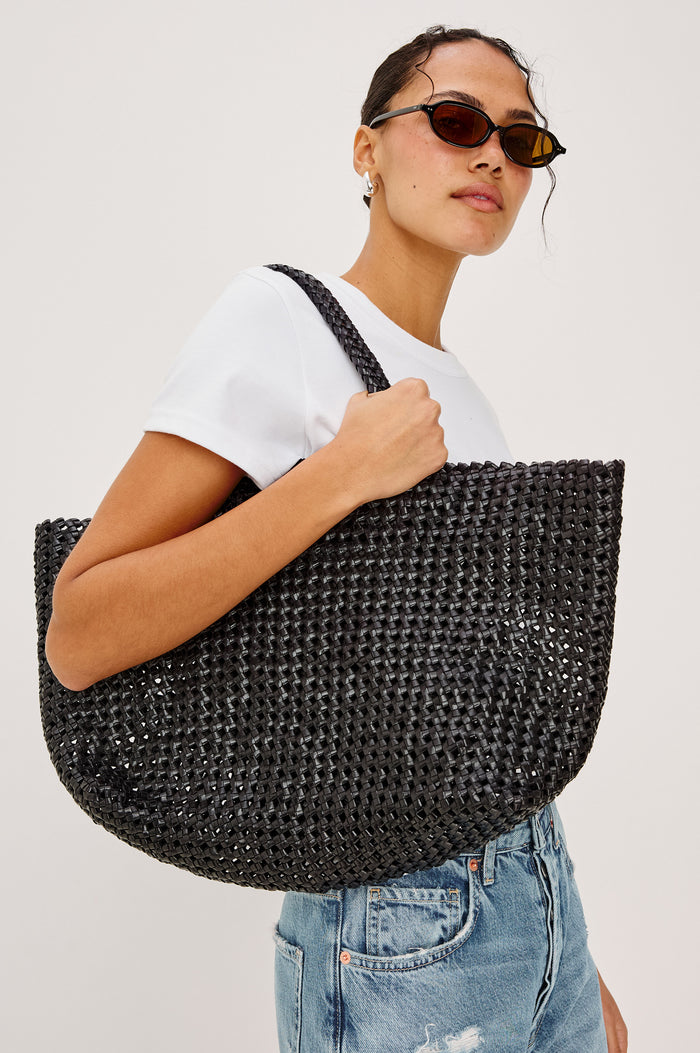 Brava Tote in Woven Leather With Top Handles and Spacious Interior in Black Colorway - Upper Body View Featured on Model