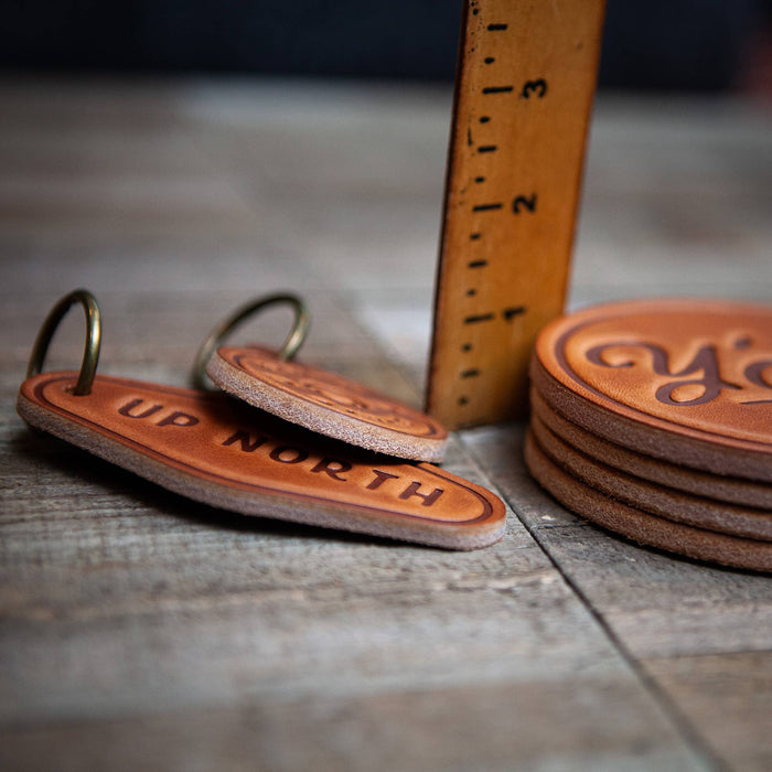 Leather keychains and coasters with a ruler.