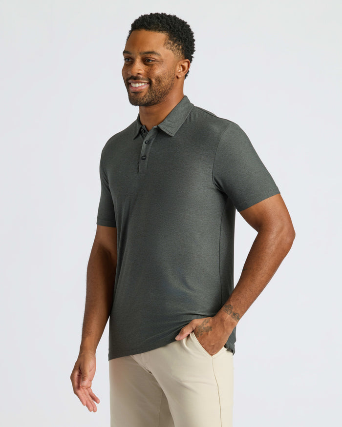 Man wearing Charcoal Heather Gray Classic Polo with beige pants, smiling slightly.