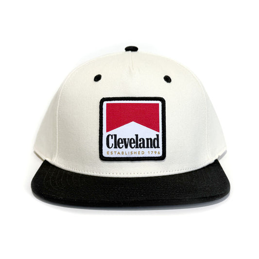 Cleveland Reds snapback hat featuring a vintage cigarette label-inspired Cleveland Established 1796 embroidered patch on an off-white and black flat brim cap