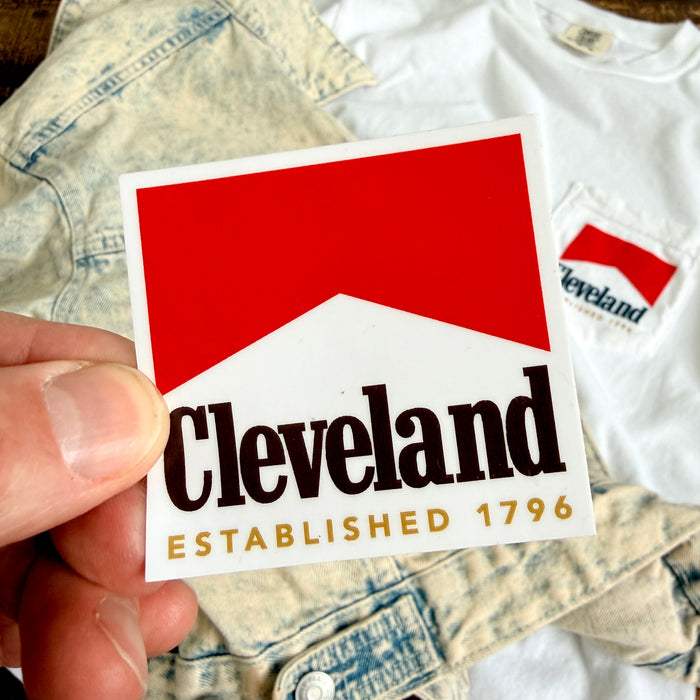 Sticker with 'Cleveland Established 1796' text held over a white shirt with a similar design.