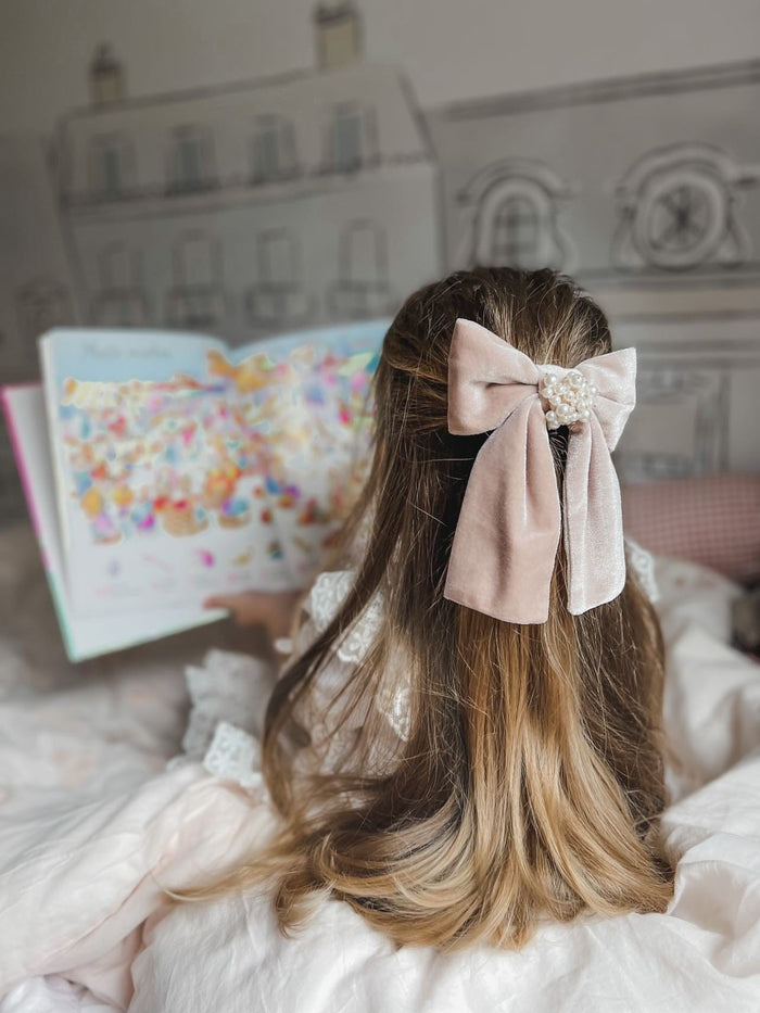 Toddler wearing Dusty Pink Velvet Hair Bow styled in hair, oversized blush velvet bow perfect for special occasions.