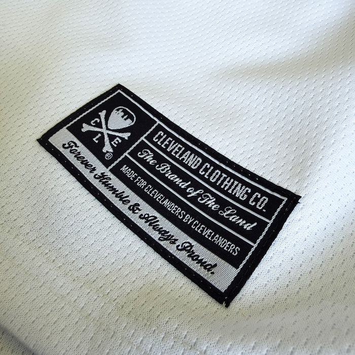 Close-up of a label on a white fabric with text and branding.