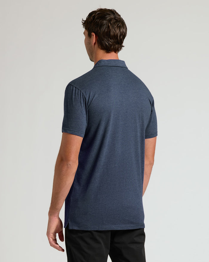 Man wearing a blue polo shirt on a light gray background