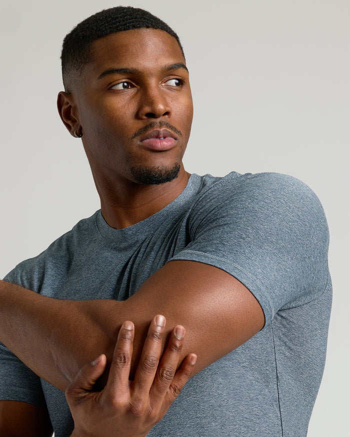 Young man stretching in Neutral Short Sleeve Tall Active Crew.
