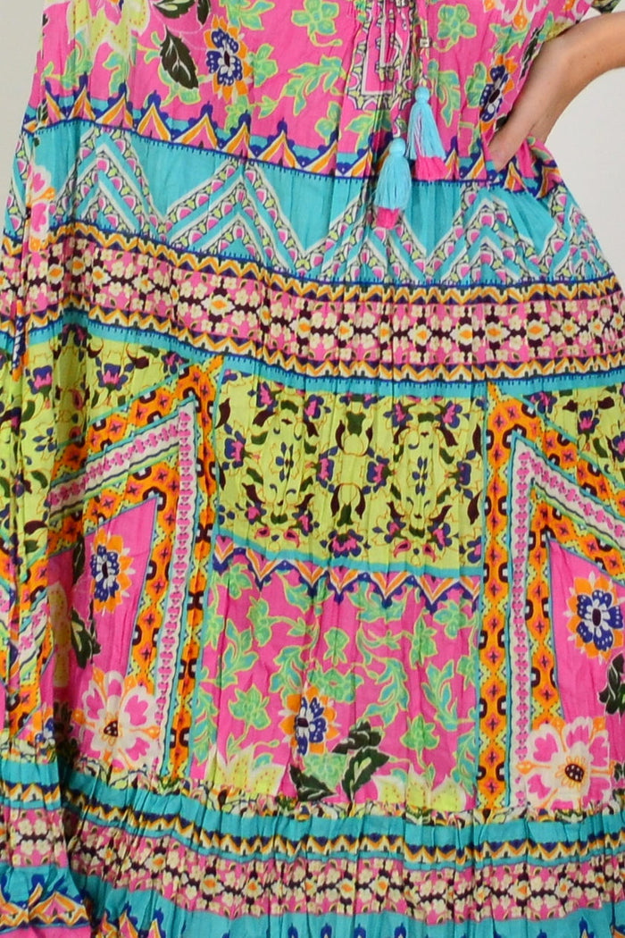 Orientique Iruya Crinkle Tie Neck Tunic Dress displayed flat with tie neckline and crinkled fabric, in a vibrant, colorful pattern.