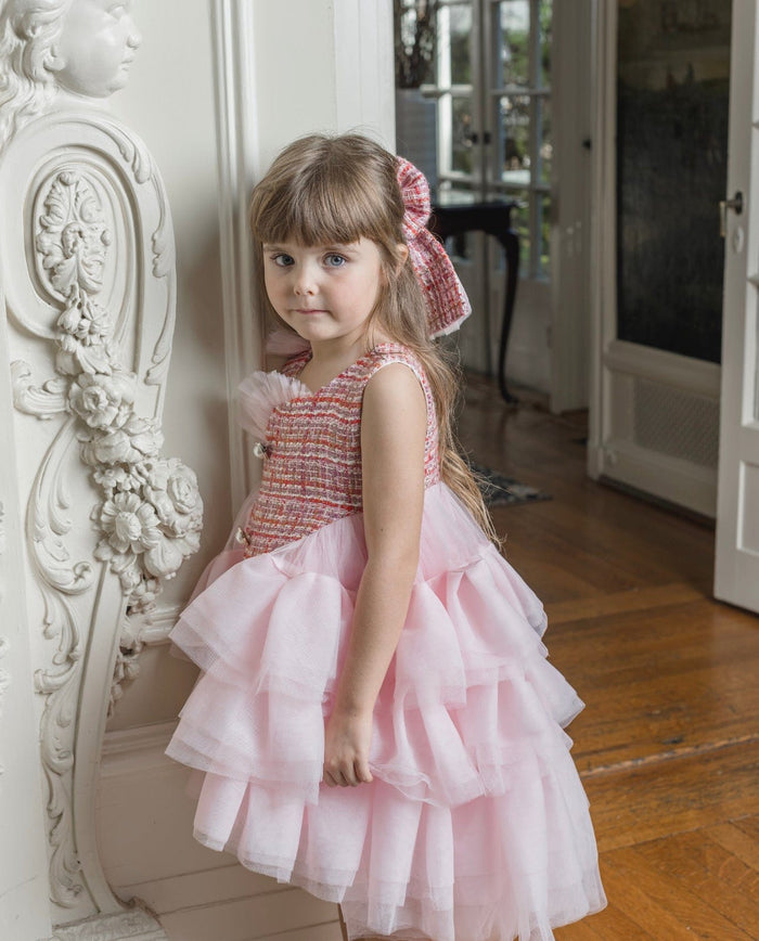 Kellie Pink Tweed Hair Bow worn with matching pink dress, featuring classic oversized silhouette and woven tweed texture – elegant girls boutique hair accessory.