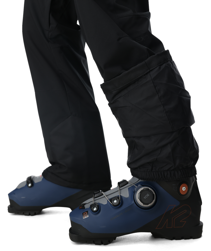 Blue ski boots with black pants on a white background