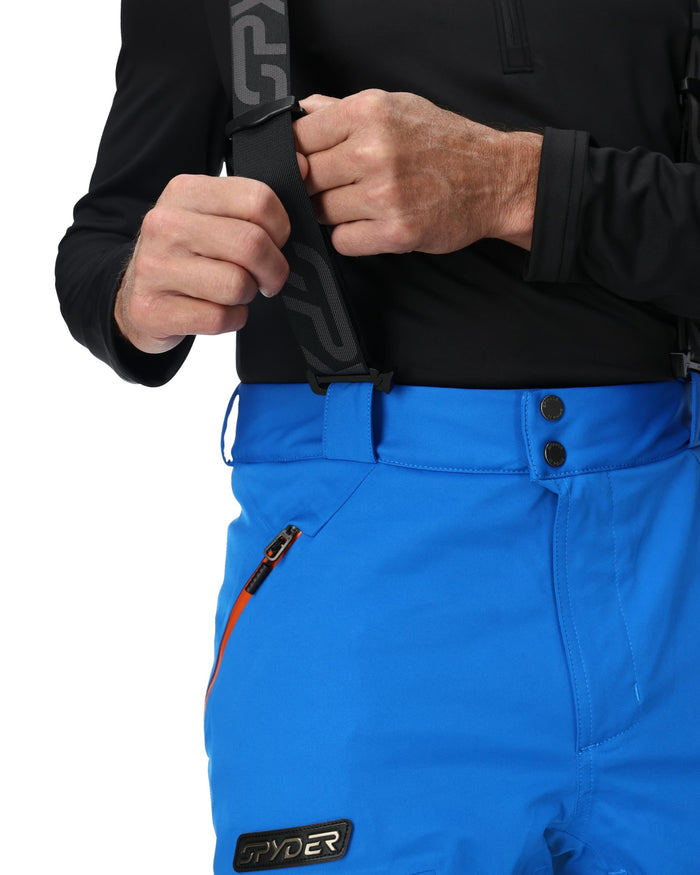 Person wearing blue ski pants with a black waistband and a visible brand logo.