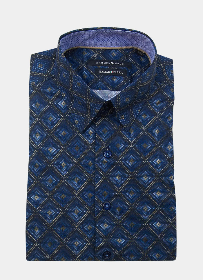 The Mosaic is a folded long-sleeve button-up shirt featuring a blue geometric diamond pattern, with an “Italian Fabric” label inside the collar.