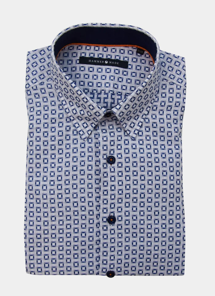The Ogilvie men's dress shirt features long sleeves, a blue geometric square pattern, and dark buttons, neatly folded.