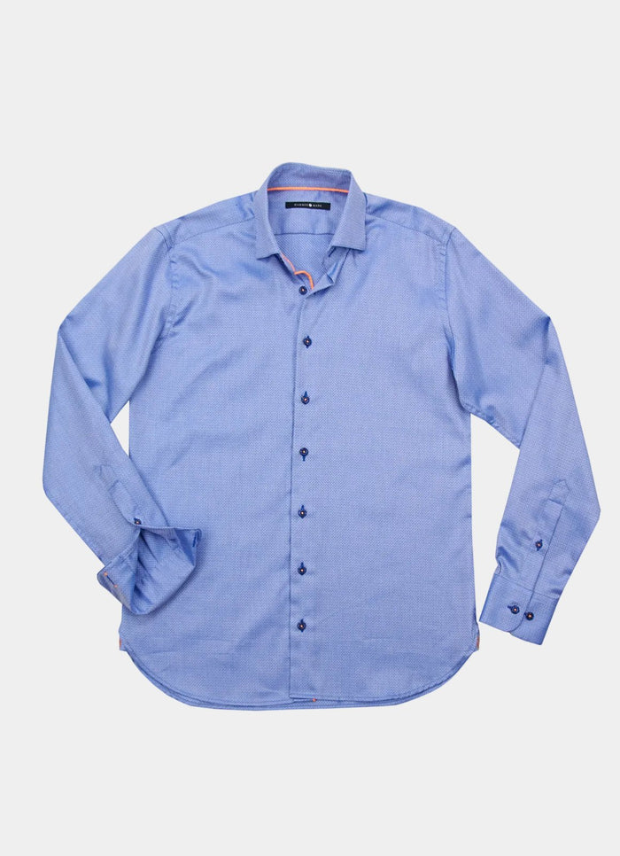 The Padua is a light blue, long-sleeve button-up dress shirt with a collar, shown laid flat on a white background.