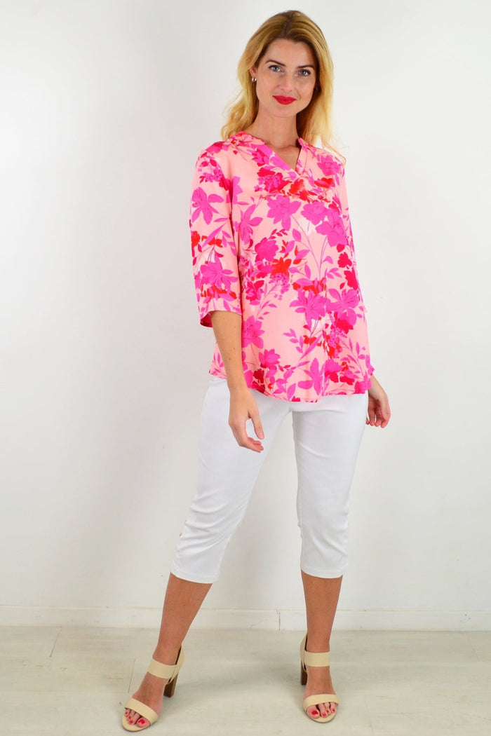 Colorful floral tunic top by I Love Tunics with vibrant flower patterns and a relaxed fit, displayed on a hanger.