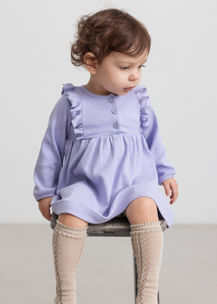 Children wearing purple ribbed dress with ruffle details and long sleeves