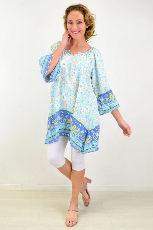 Light pink Tree Carnations print tunic top by Style Fashion, featuring a relaxed fit and floral design, displayed on a hanger.