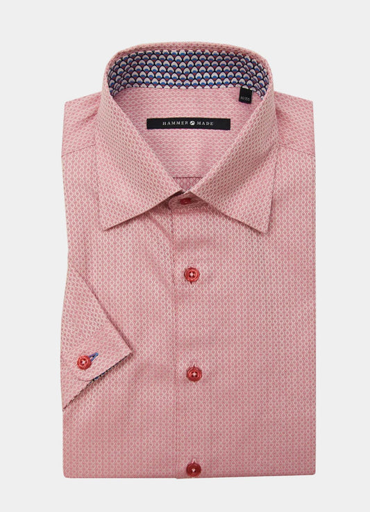 The Waite shirt is a folded long-sleeve dress shirt in a pink pattern with red buttons and a contrasting inner collar detail.