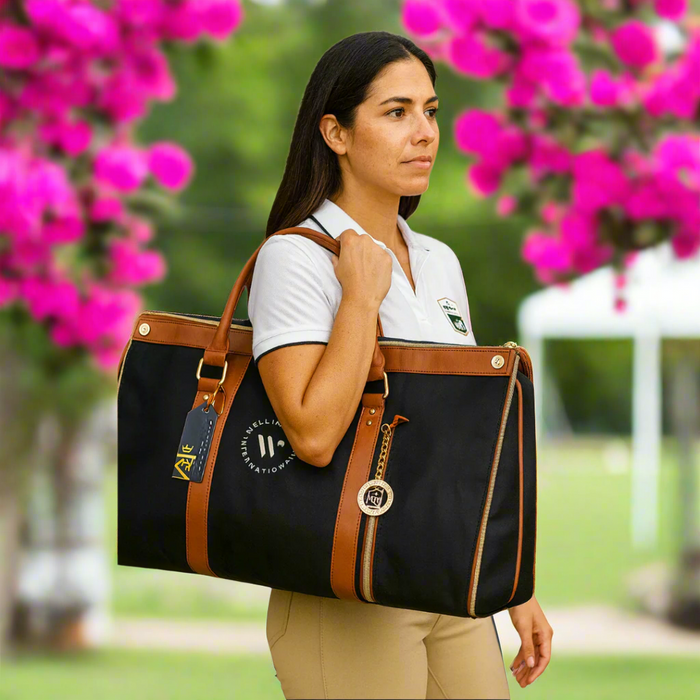 woman holding black garment bag with logo outside