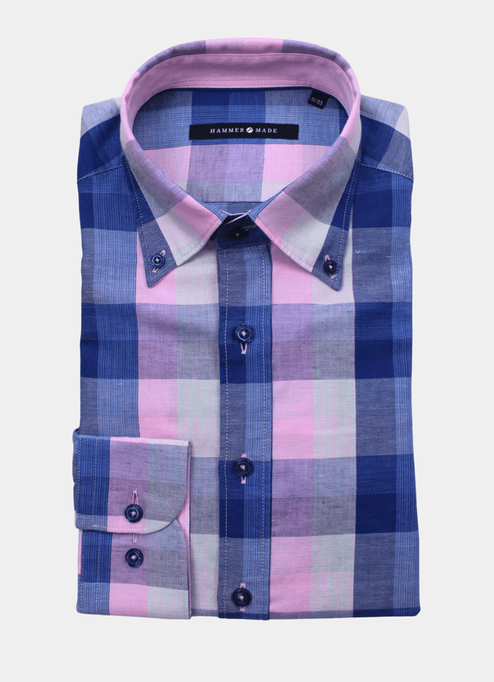 The Wendell is a folded men’s long sleeve shirt in pink and navy with a large blue, pink, and gray check pattern, complete with a front pocket and collar—perfect for a polished look.