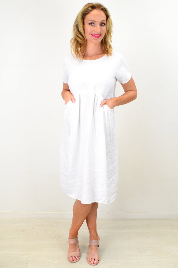 White linen Sunday best tunic dress by Cali&Co featuring a relaxed fit, short sleeves, and a classic neckline on a model.