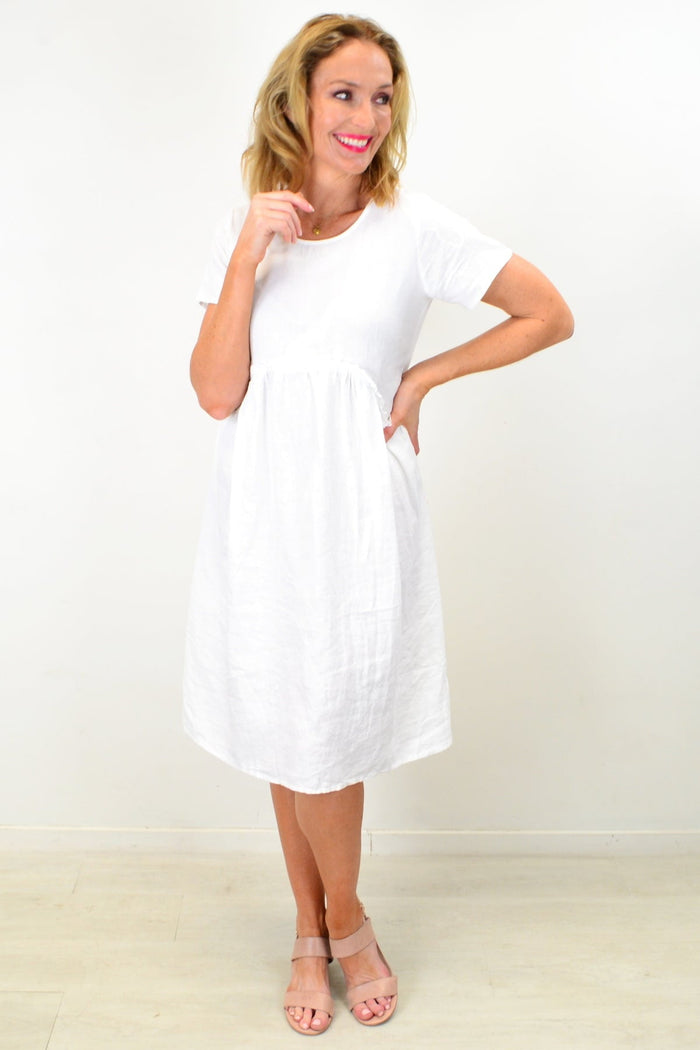 White linen Sunday best tunic dress by Cali&Co, featuring a relaxed fit and elegant design, shown on a hanger.